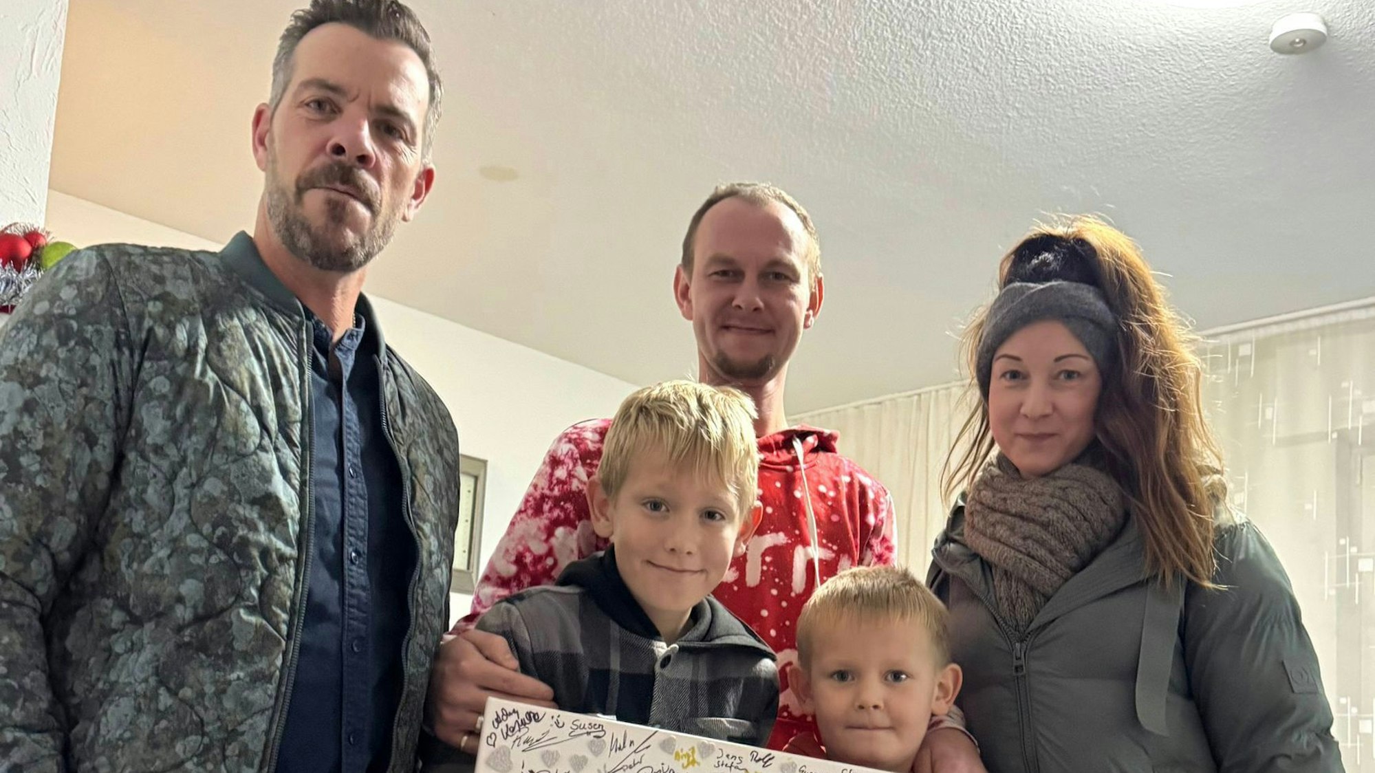 Drei Erwachsene und zwei Kinder schauen in die Kamera.