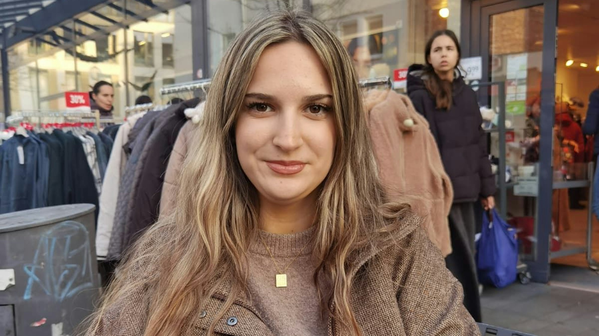 Eine junge Frau mit mittelblondem Haar lächelt in die Kamera.