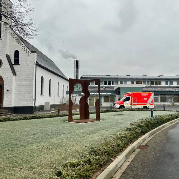 Ein Rettungswagen steht vor einem Krankenhaus.
