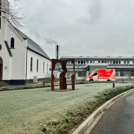 Ein Rettungswagen steht vor einem Krankenhaus.