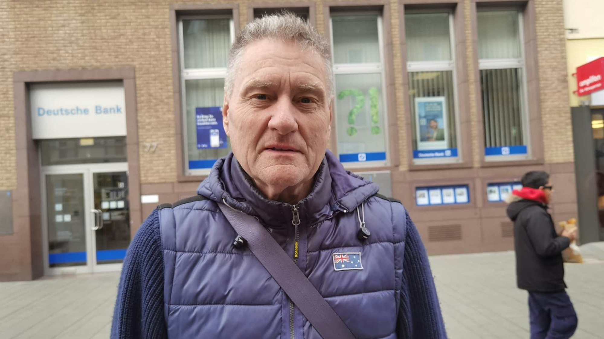 Ein Mann mit einer Winterweste schaut in die Kamera.