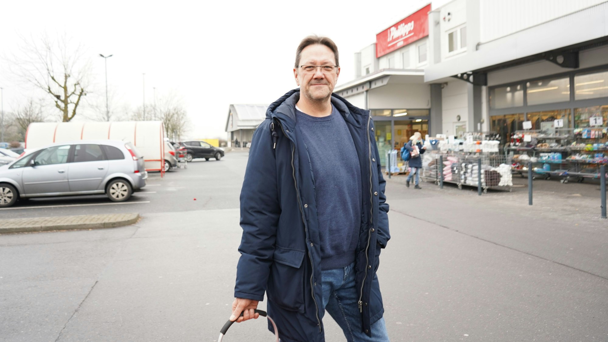 Das Foto zeigt einen Mann auf einem Parkplatz.