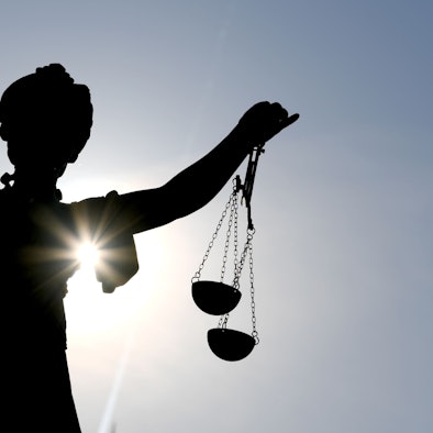 Die Göttin Justitia im Gegenlicht auf dem Gerechtigkeitsbrunnen in Frankfurt am Main.