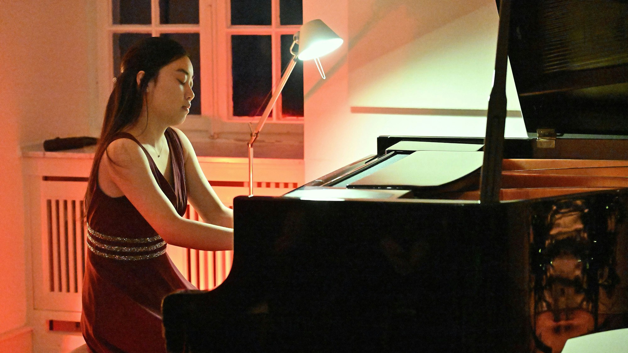 Eine Frau sitzt am Klavier.