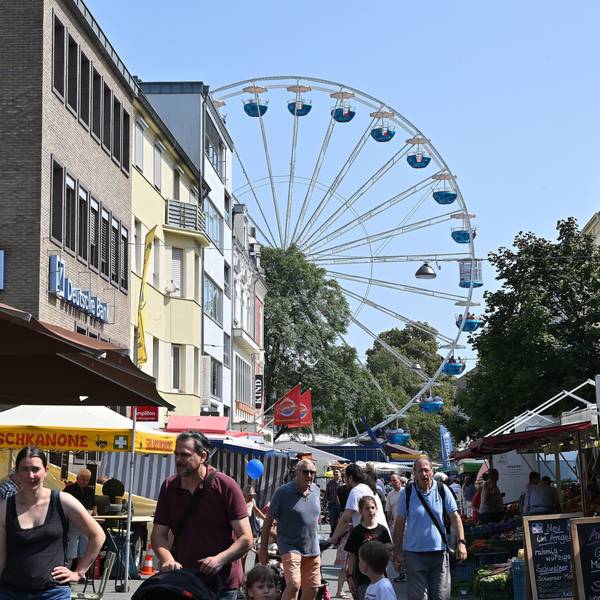 Im Vordergrund Menschen, im Hintergrund ein Riesenrad
