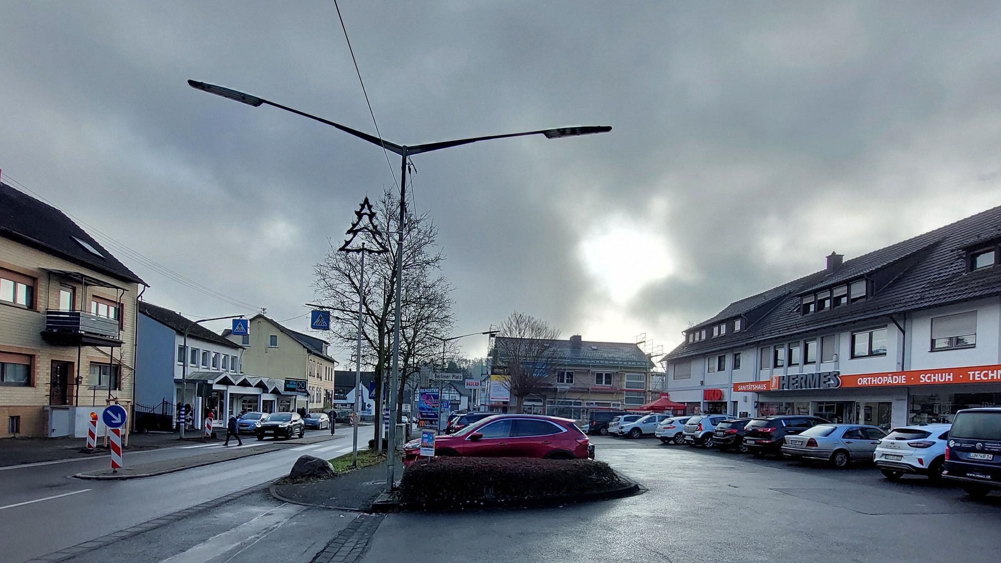 Autos auf dem Parkplatz vor einer Ladenzeile.