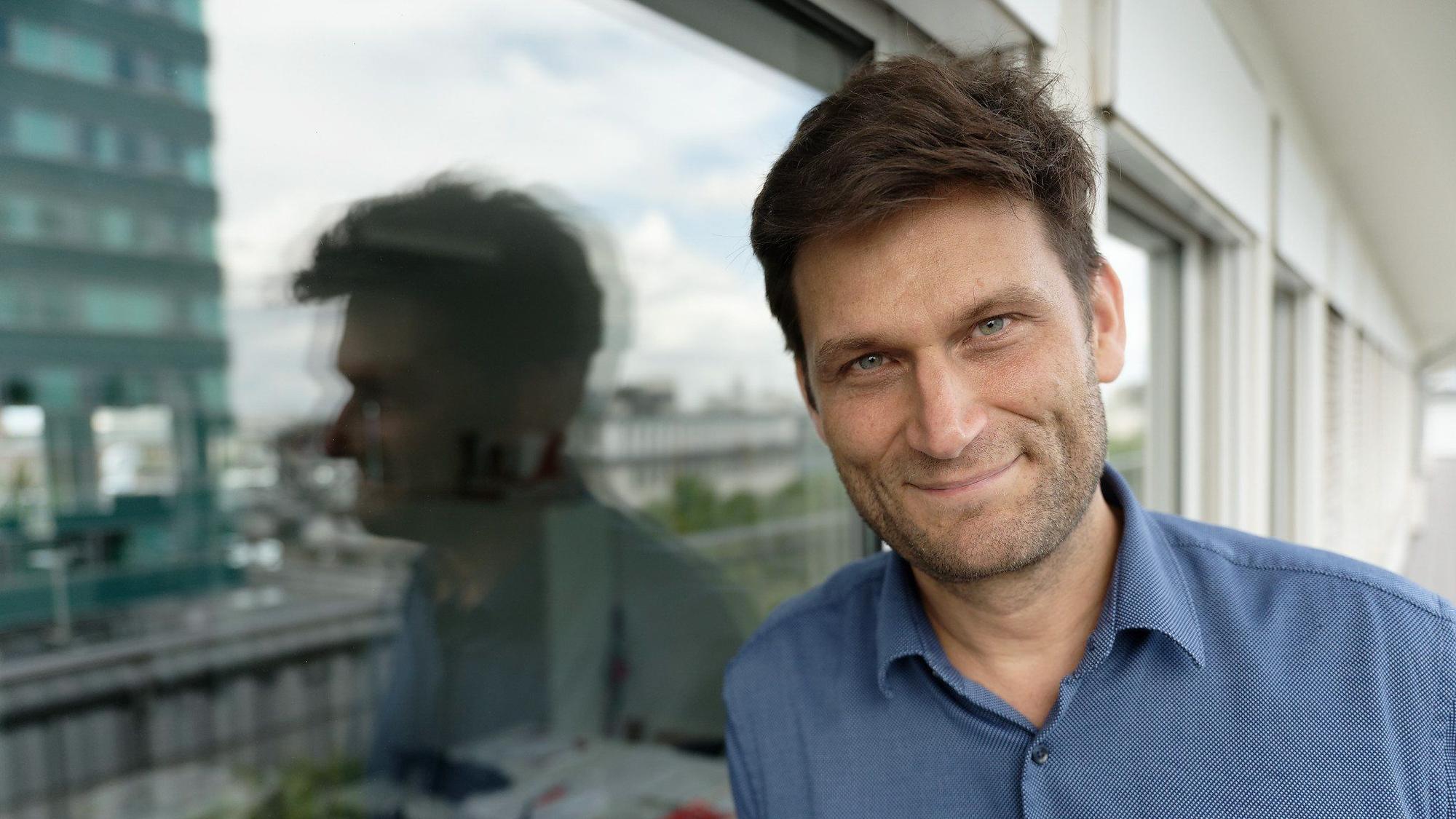 Der Fernsehmoderator, Kabarettist und Autor Christian Ehring steht auf einem Balkon.