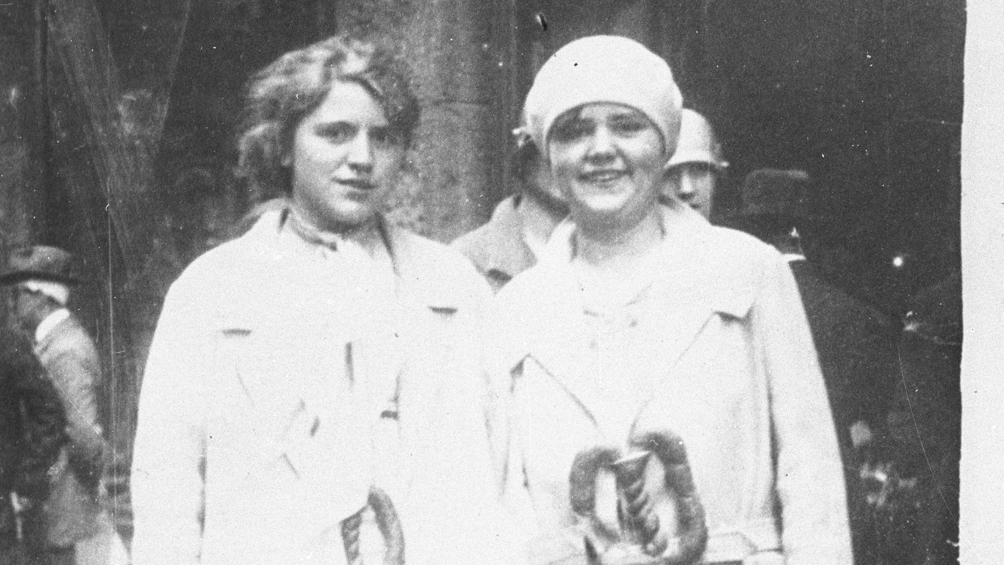 Dieser historische Brauch zum Jahreswechsel werden auch heute noch im Rheinland gepflegt. Mädchen in weißen Kleidern mit umgehängten Neujahrsbrezeln in der Stadt. (Bild aus dem Jahr 1928)