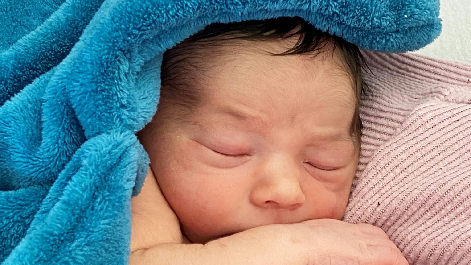 Ein Neugeborenes kuschelt sich in ein Handtuch