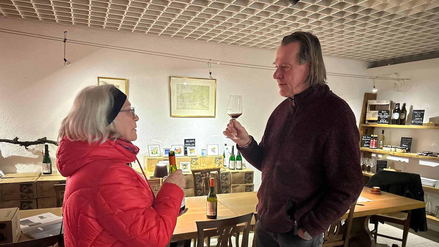 Winzer Kay Thiel und Brigitte Schmälter, die mit ihm über Wein diskutiert.