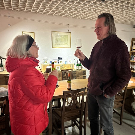 Winzer Kay Thiel und Brigitte Schmälter, die mit ihm über Wein diskutiert.
