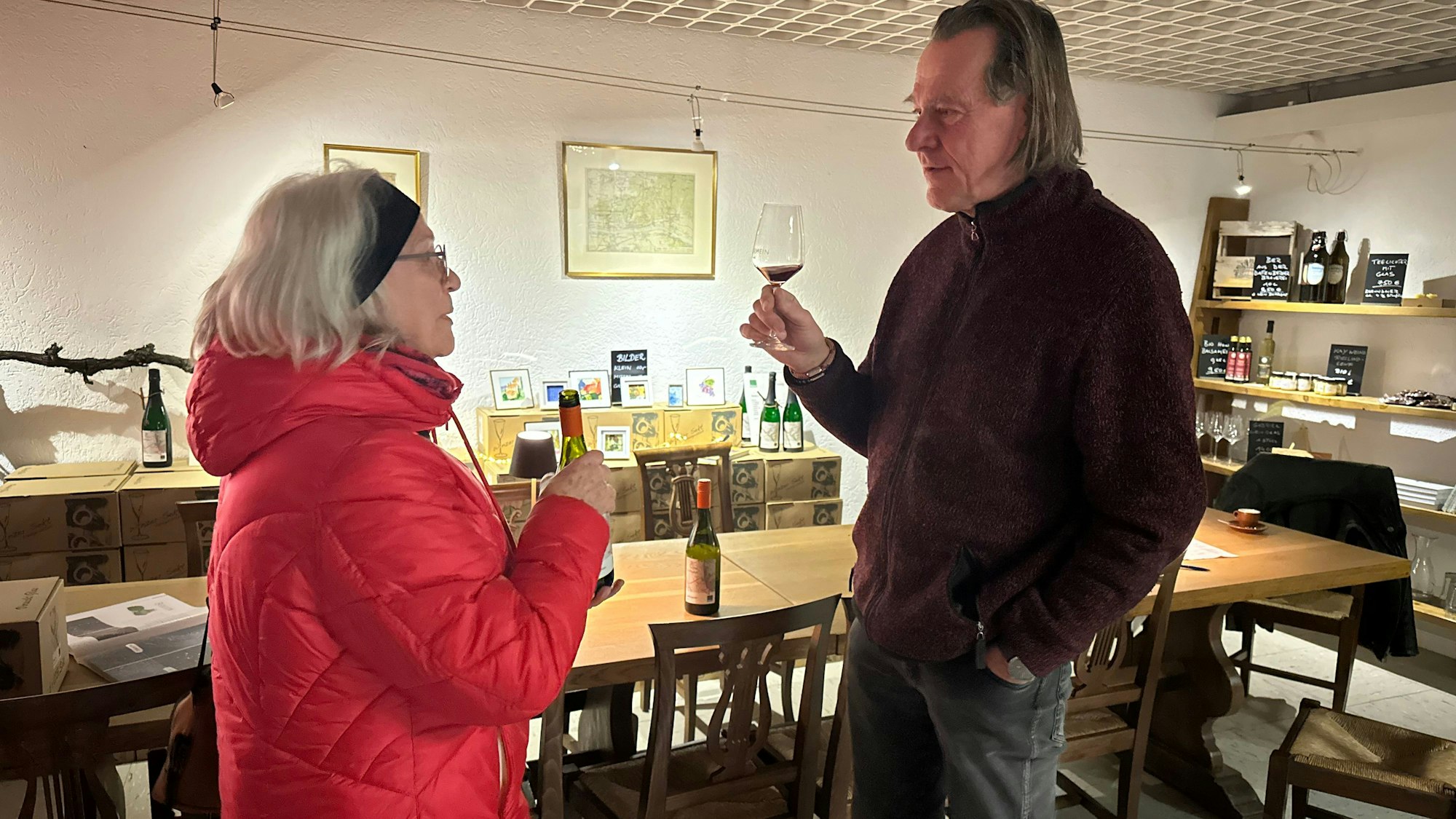 Winzer Kay Thiel und Brigitte Schmälter, die mit ihm über Wein diskutiert.