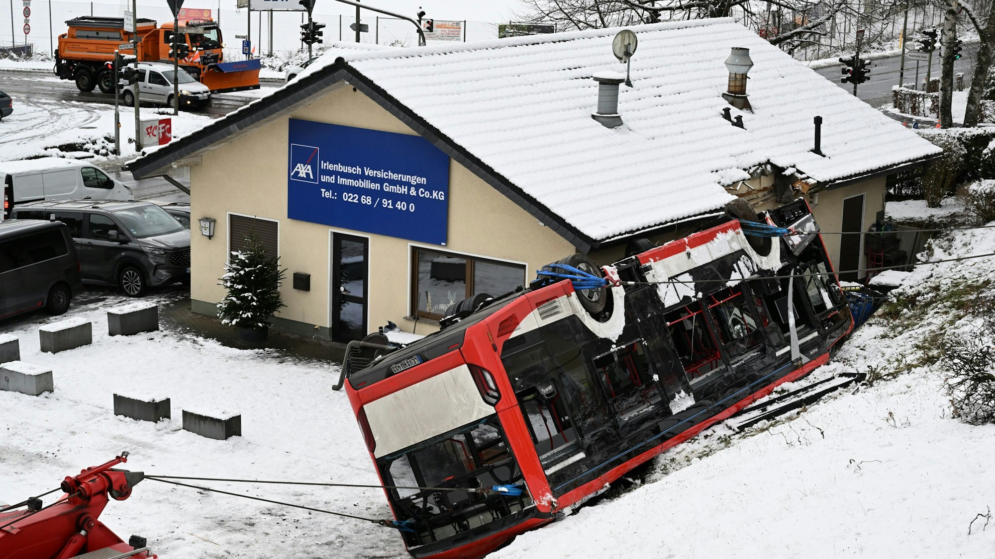 Der Bus liegt auf dem Dach und hat sich in das Gebäude verkeilt.