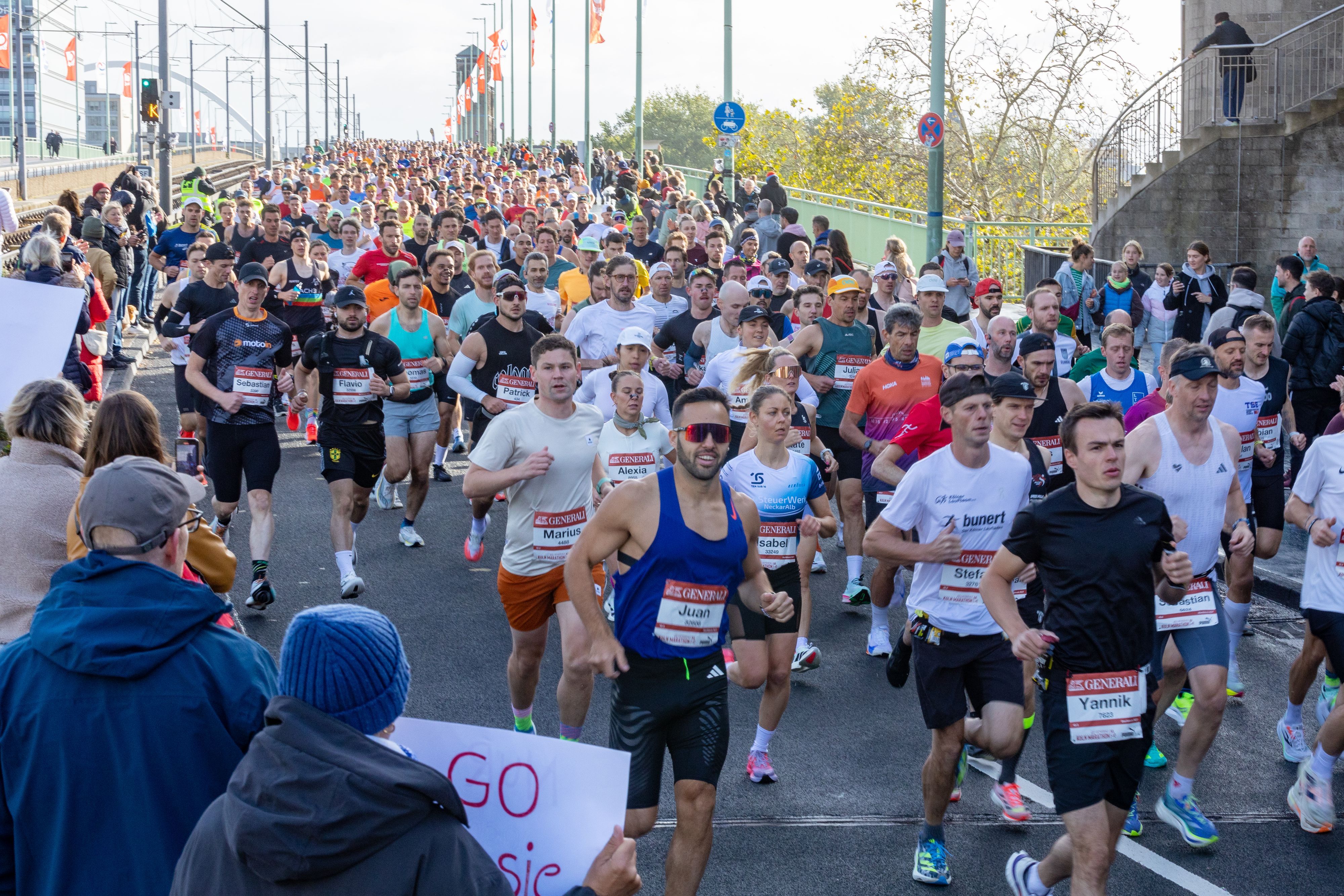 Die Massen laufen nach dem Start des 27. Köln-Marathon auf dem Ottoplatz über die Deutzer Brücke.