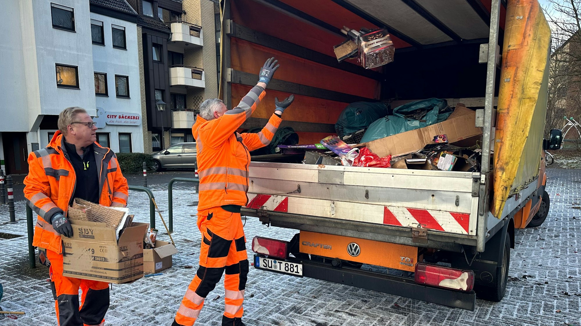 Am Europaplatz in Troisdorf werden die Knallerreste nach Silvester weggeräumt. Im Einsatz sind Robert Pietza (l.) und Andreas Kalinowski vom Bauhof der Stadt Troisdorf.