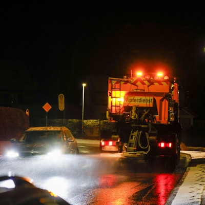 Ein Streu- und Räumfahrzeug des Winterdienst fährt auf einer Straße