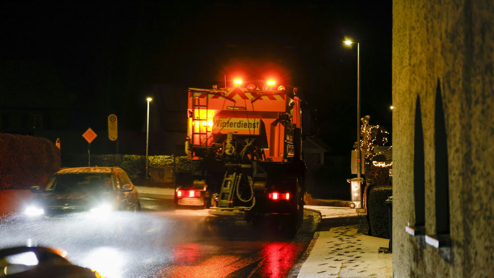 Ein Streu- und Räumfahrzeug des Winterdienst fährt auf einer Straße