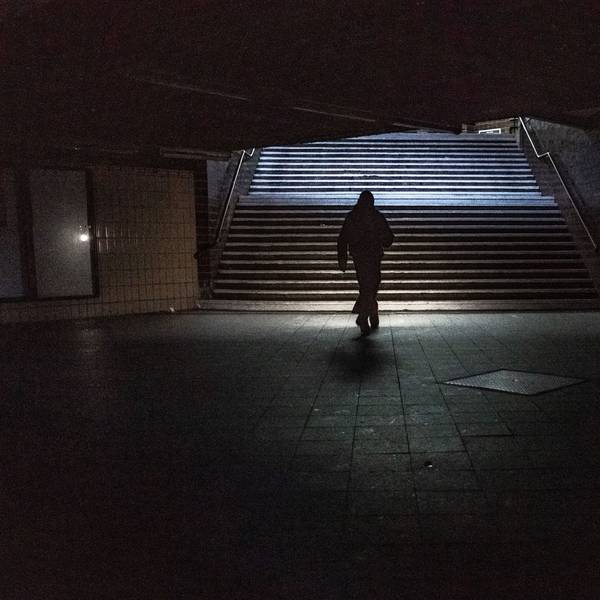 Das Foto zeigt eine Frau in einer Unterführung, in der das Licht ausgefallen ist.
