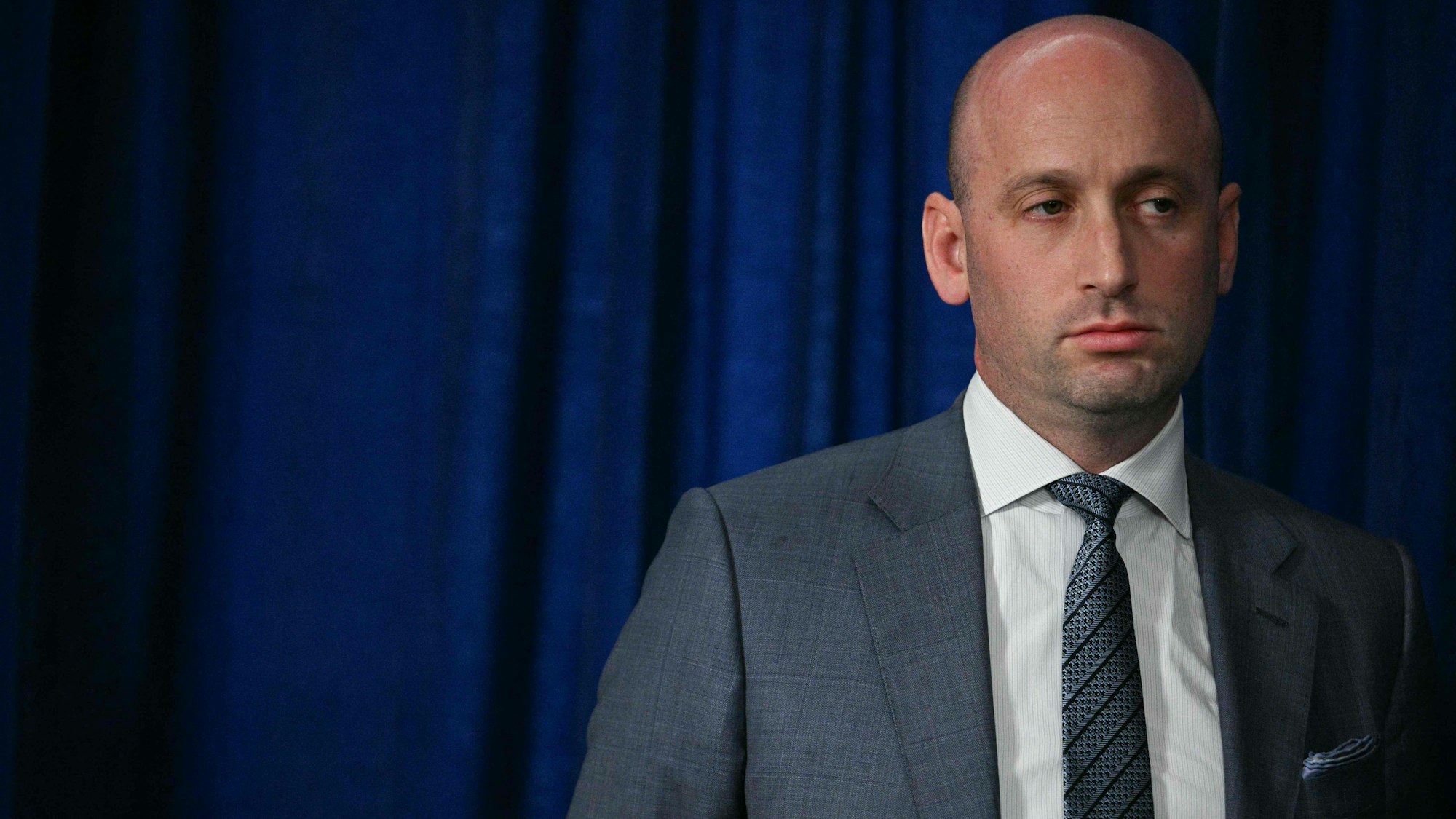 Der stellvertretende Stabschef des Weißen Hauses, Stephen Miller, hört zu, während Präsident Donald Trump nach US-Militäreinsätzen in Venezuela am 3. Januar 2026 in seiner Residenz Mar-a-Lago in Palm Beach, Florida, mit der Presse spricht.