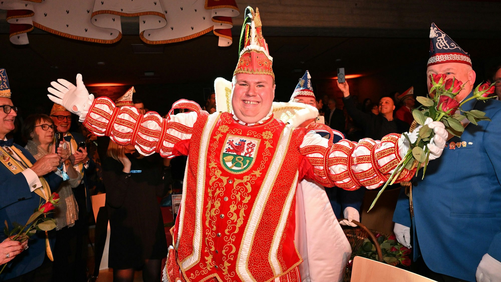 Der Prinz breitet die Arme aus und hält Rosen in der Hand.