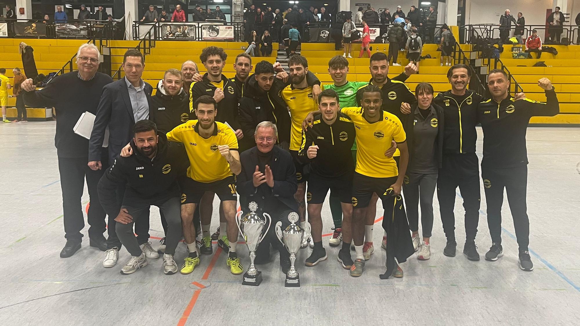Zu sehen ist eine Fußballmannschaft, die ein Hallenturnier gewonnen hat.