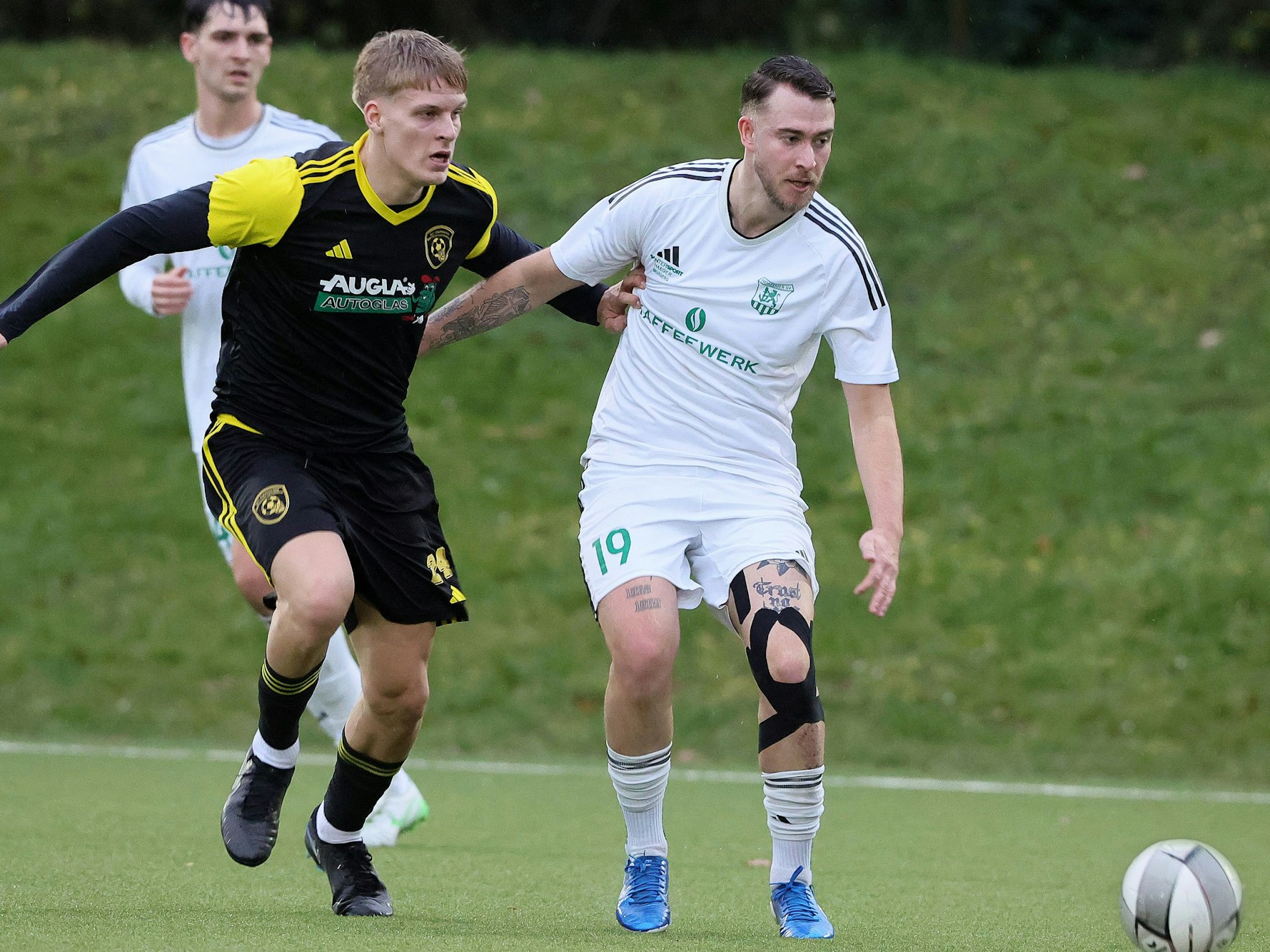 Das Foto zeigt einen Lechenicher Fußballer und einen Horremer, beide blicken dem Ball hinterher.