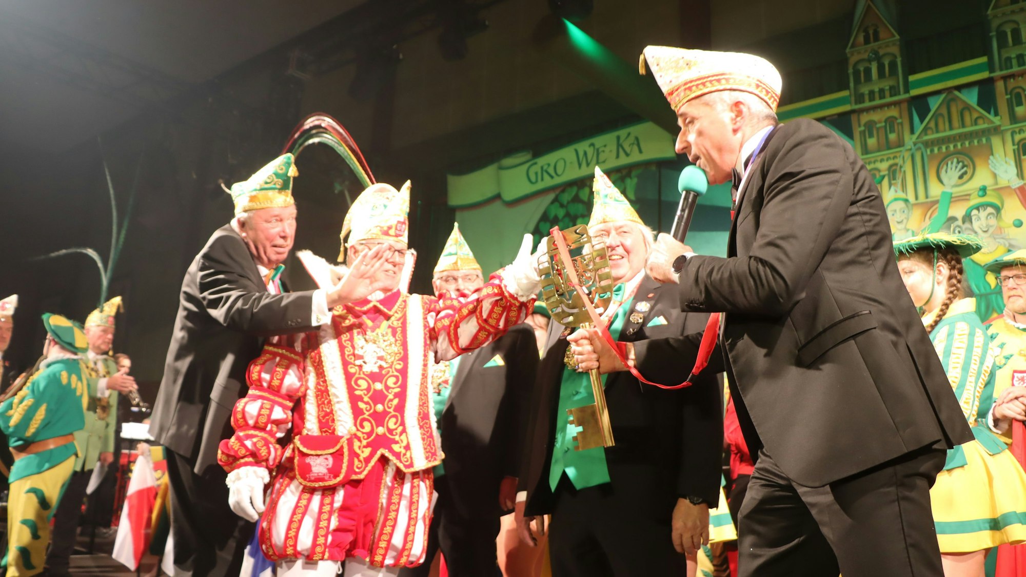 Fünf Karnevalisten, im Mittelpunkt ein riesiger Schlüssel.