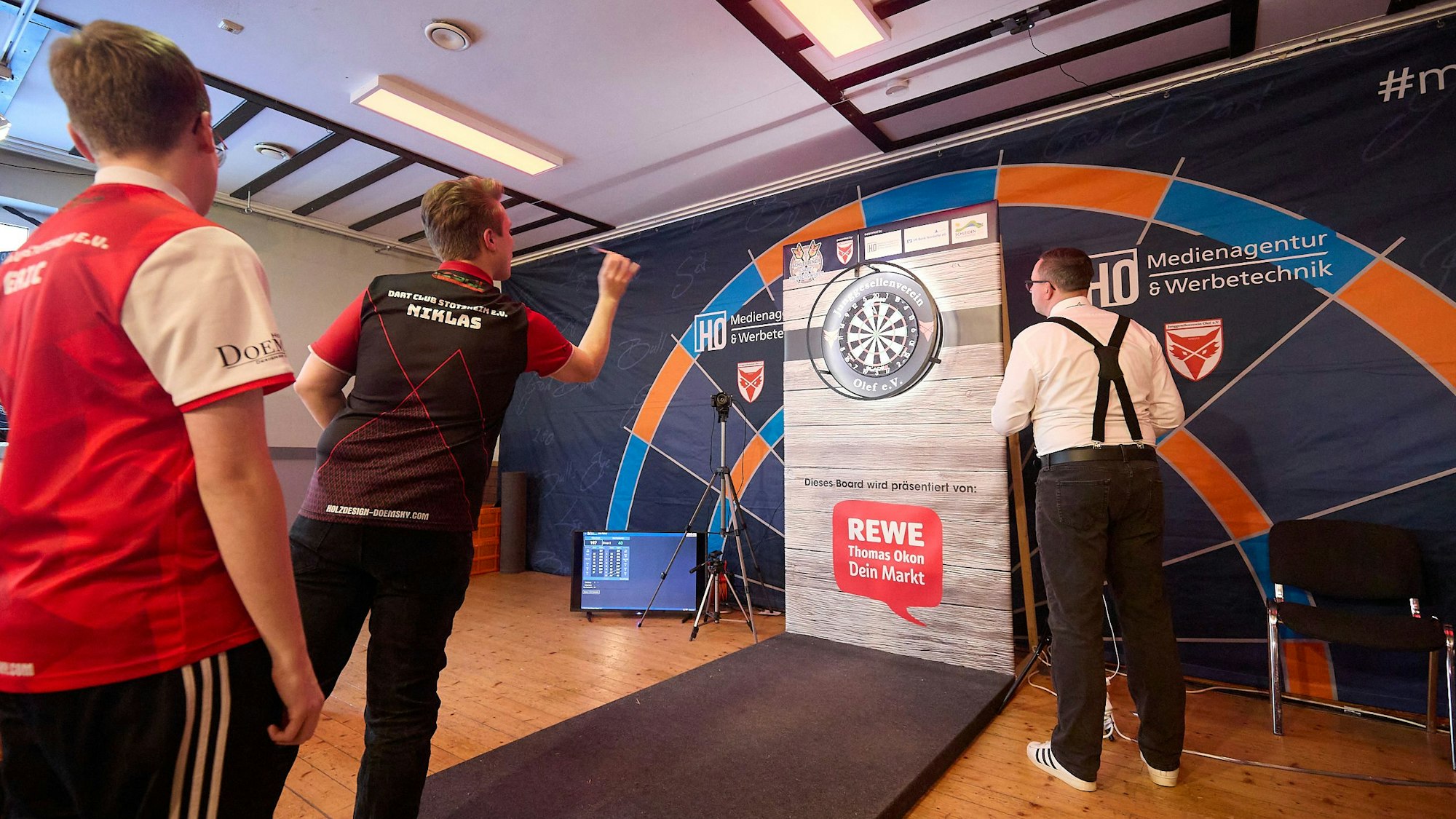 Das Bild zeigt einen Darter beim Werfen der Pfeile.