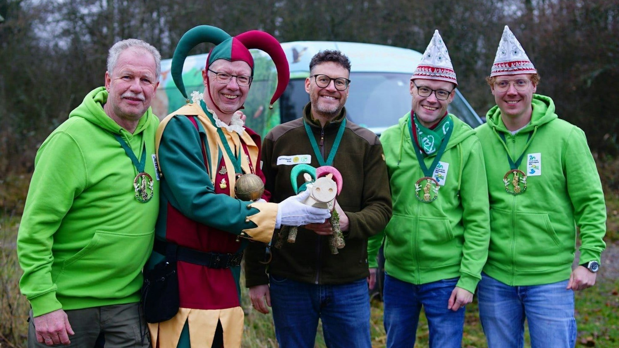 Fünf Männer stehen nebeneinander und präsentieren ein selbst gebasteltes Nationalparkschwein. Dirk Gemünd trägt ein Kostüm.