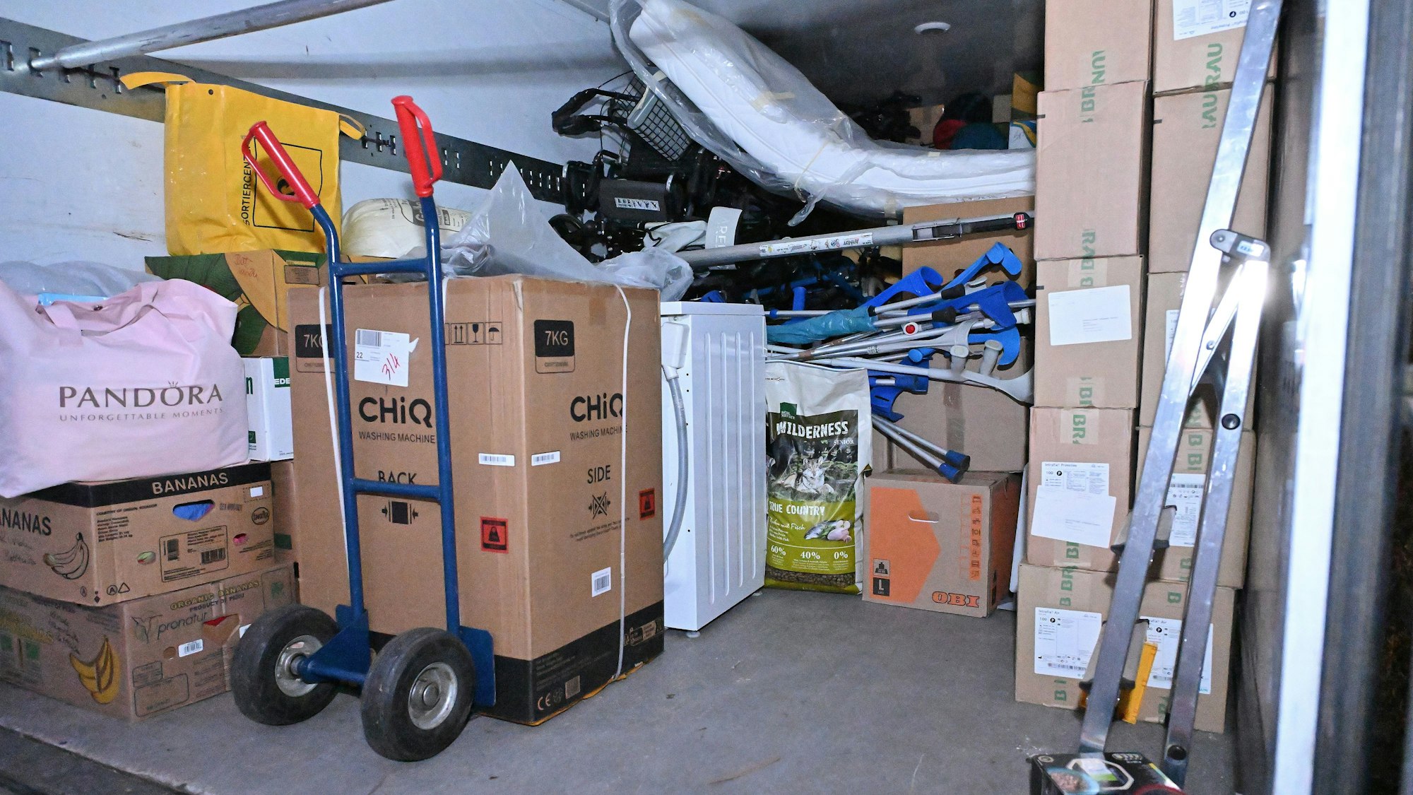 Der Blick in die Lagerhalle zeigt zum Beispiel ein Krankenbett, Gehkrücken, und eine Waschmaschine.