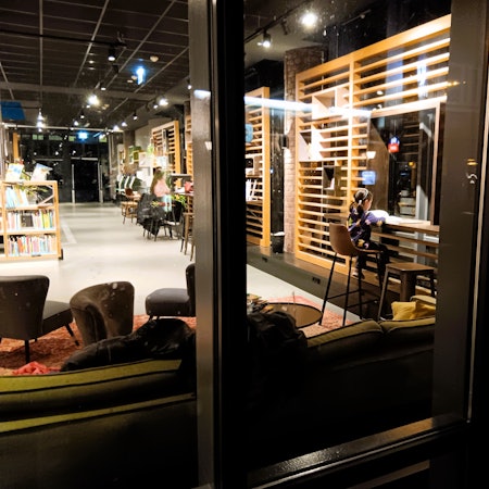 Ein junges Mädchen liest an einem Tisch in einer modernen Bibliothek.