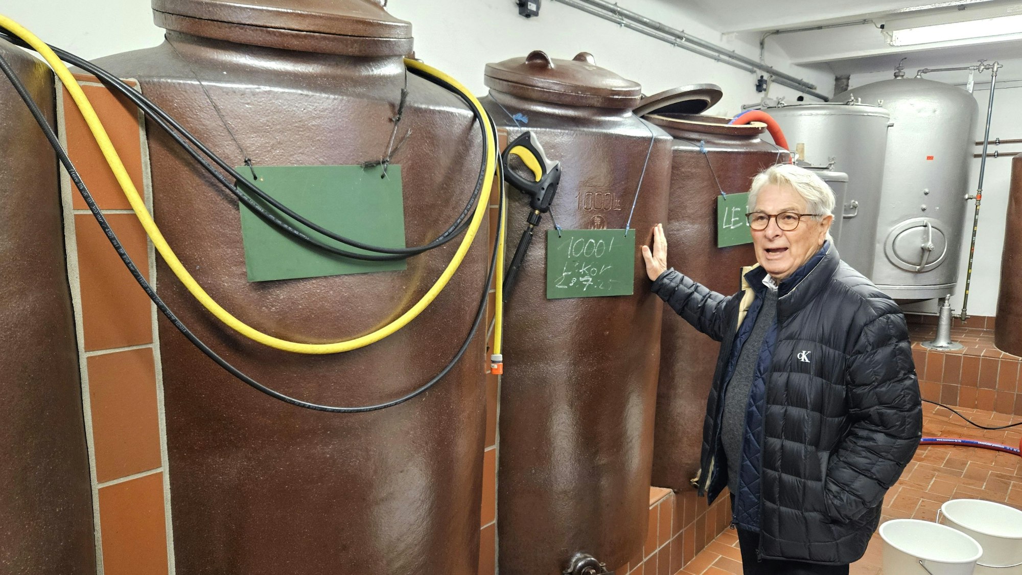 Wolfgang Scheidtweiler steht vor den mannshohen Steinkrügen.