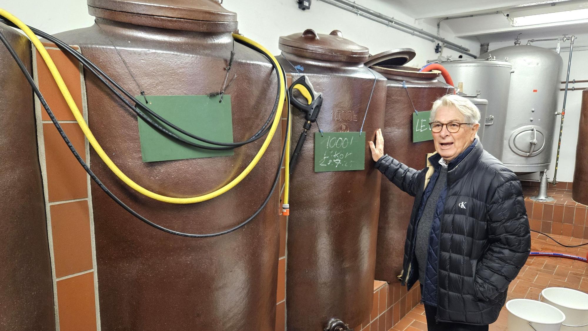 Wolfgang Scheidtweiler steht vor den mannshohen Steinkrügen.