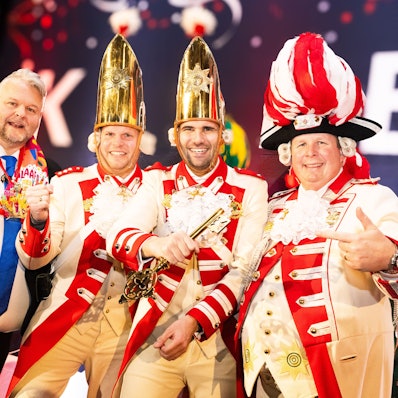 Hoteldirektor Holger Hess überreicht dem designierten Dreigestirn den goldenen Schlüssel.