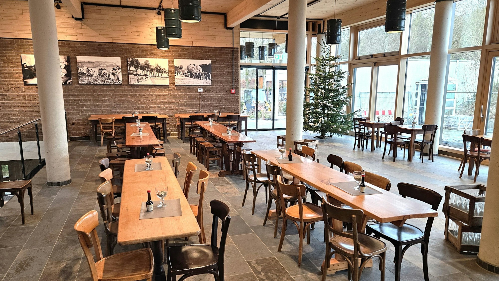 Blick in den großen Raum mit mehreren großen Tischen und Stühlen.