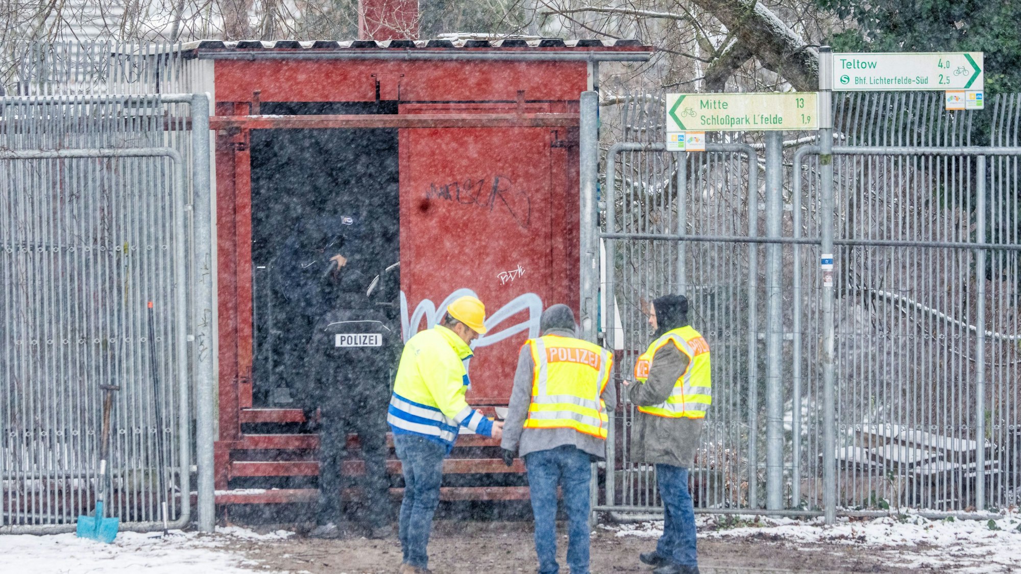 das Bild zeigt Einsatzkräfte der Polizei an der Brandstelle einer Kabelbrücke vor dem Kraftwerk Lichterfelde am Teltowkanal. Foto: Michael Kappeler/dpa