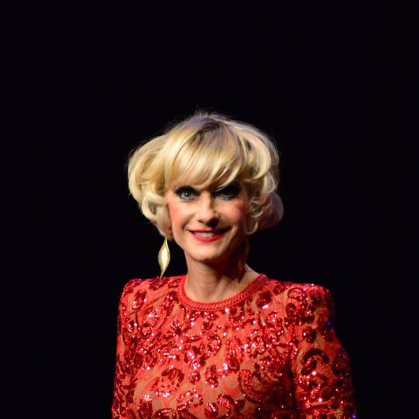 Eine Frau mit blonden Haaren im Glitzerkleid.