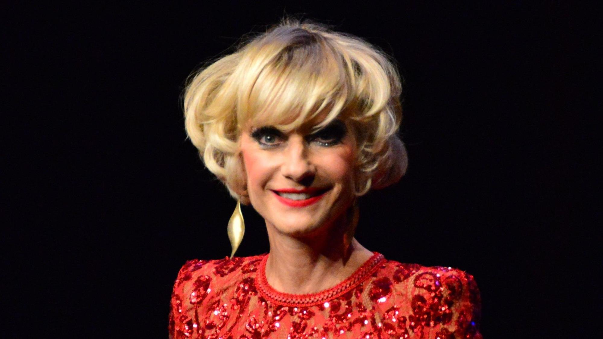 Eine Frau mit blonden Haaren im Glitzerkleid.