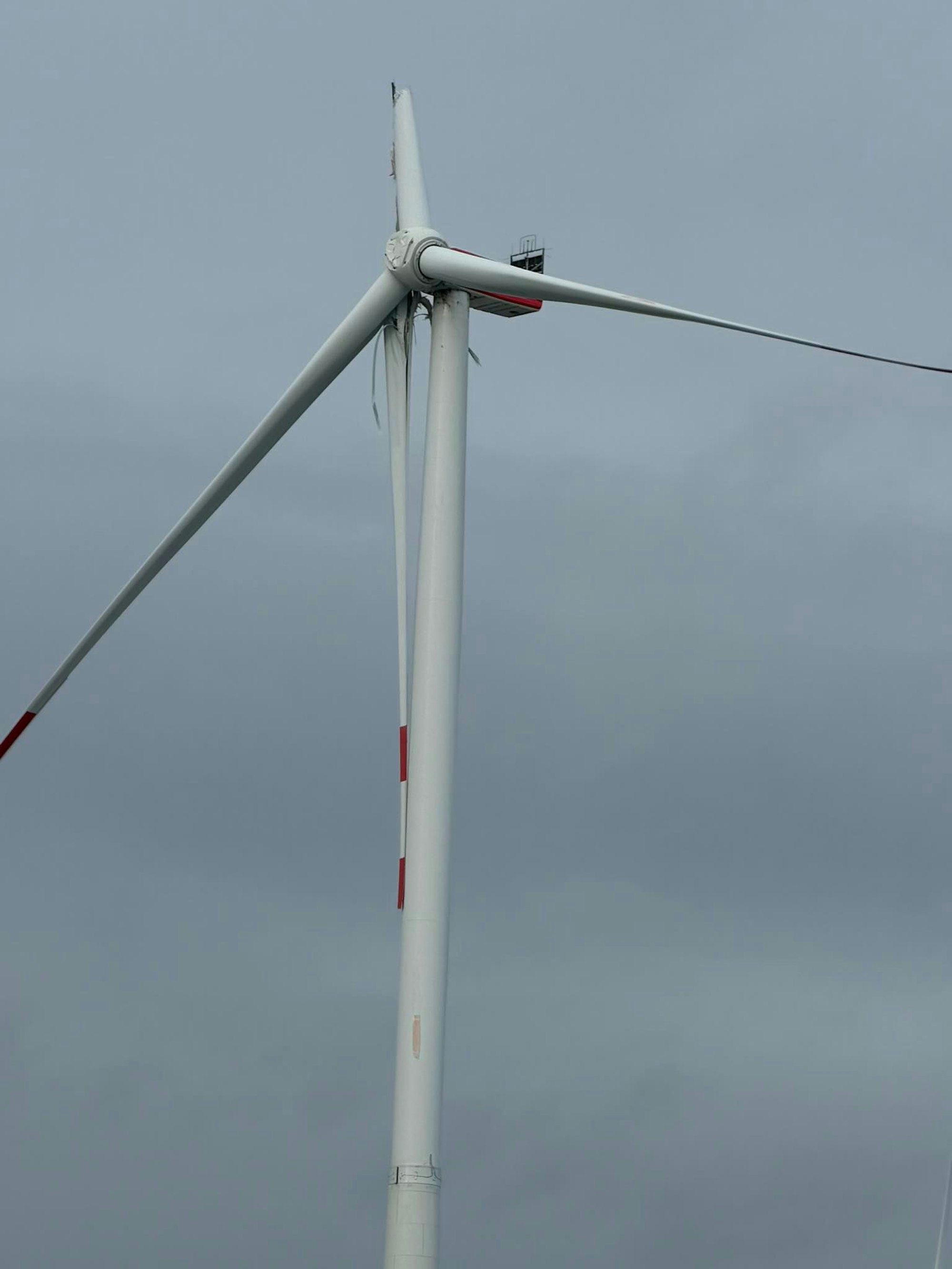 Ein Rotorblatt an einem Windkraftrad hängt herunter.