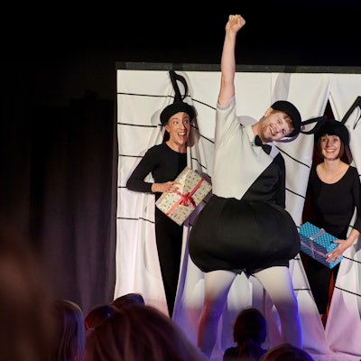 Zwei Frauen und ein Mann jubeln.