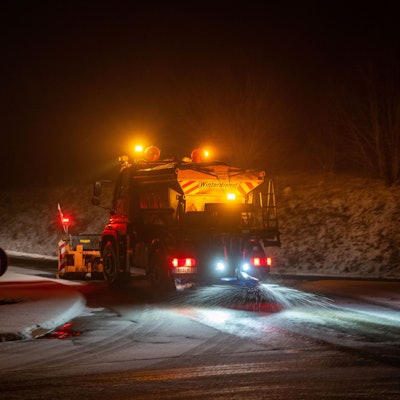 Ein Einsatzfahrzeug des Landesbetrieb Mobilität (LBM) räumt Schnee und streut eine Ausfahrt der B51 gegen Glatteis.