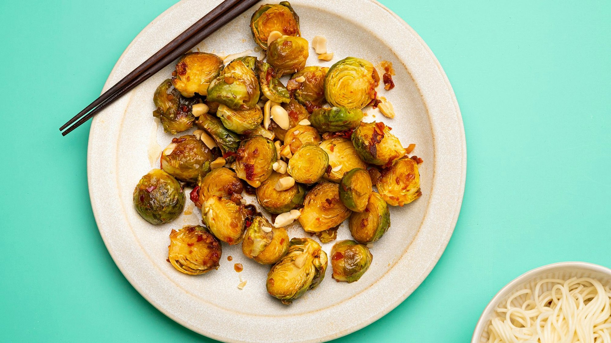 Zur spicy Variante von Rosenkohl passen Weizennudeln und ein Erdnuss-Topping.