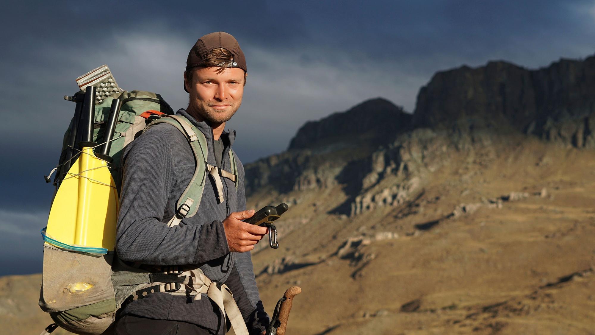 Tobias Schorcht mit Rucksack im Gebirge.