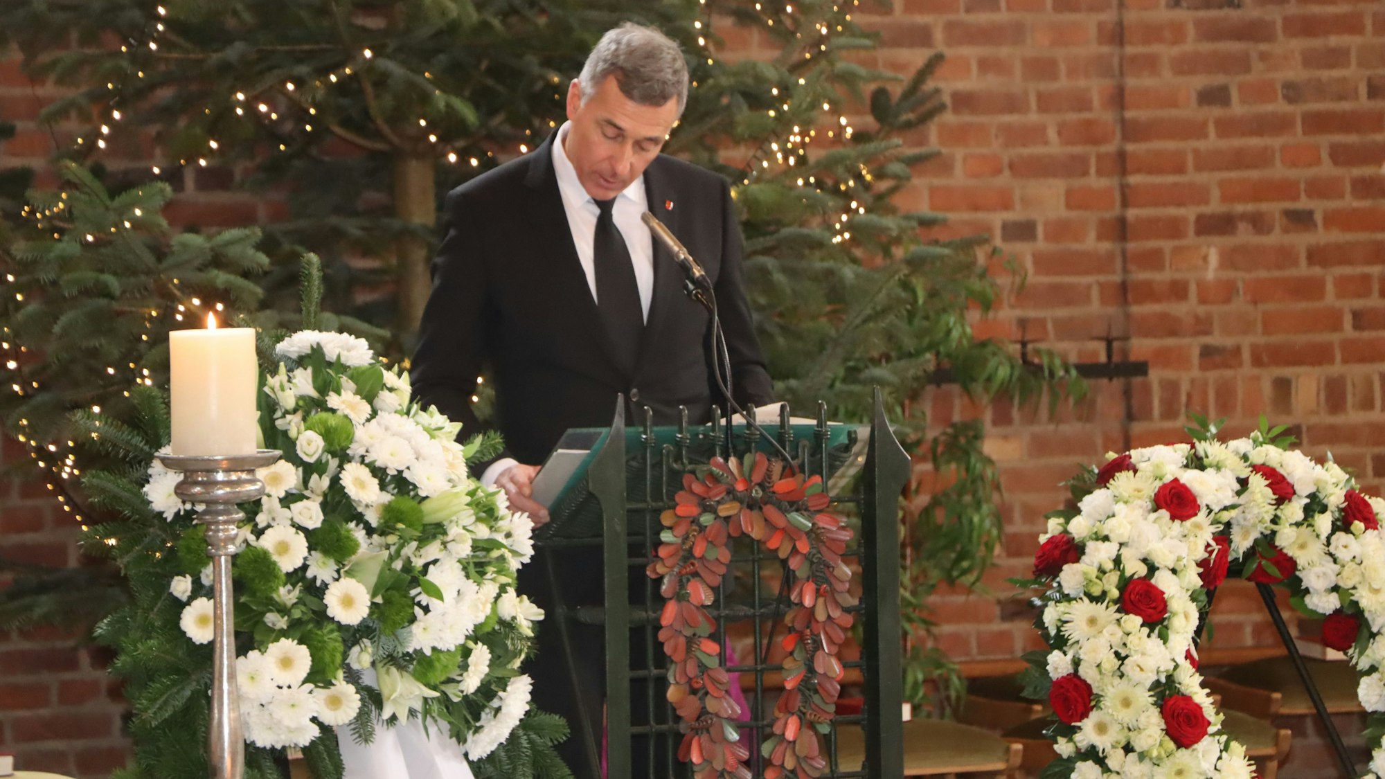 Ein Mann steht hinter einem Rednerpult.