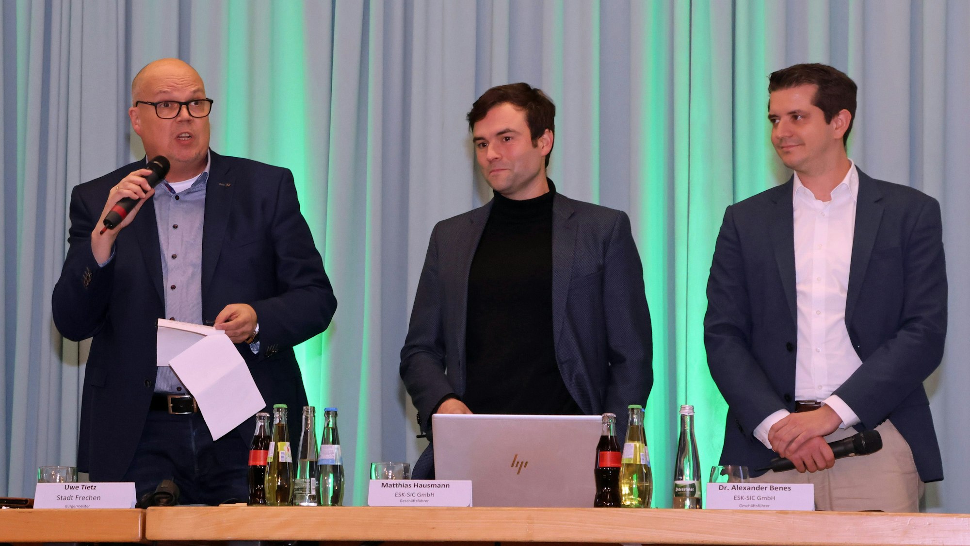 Auf dem Bild sind drei Männer mit Jacketts zu sehen.