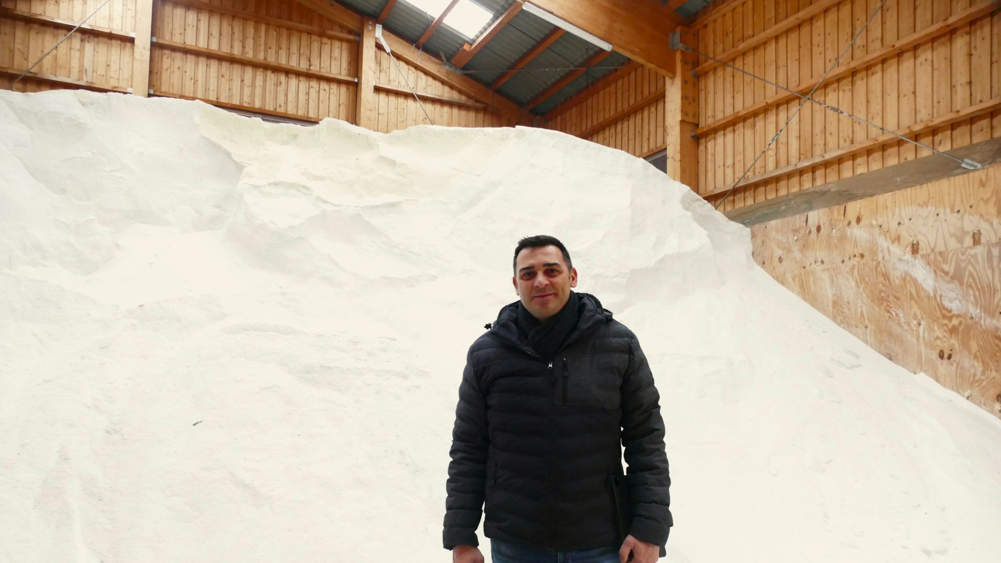 Artur Förster, Leiter des Siegburger Baubetriebshof, steht vor dem Salzberg in der Halle.
