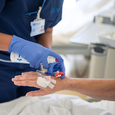 Eine Pflegekraft legt bei einem Patienten eine Infusion.