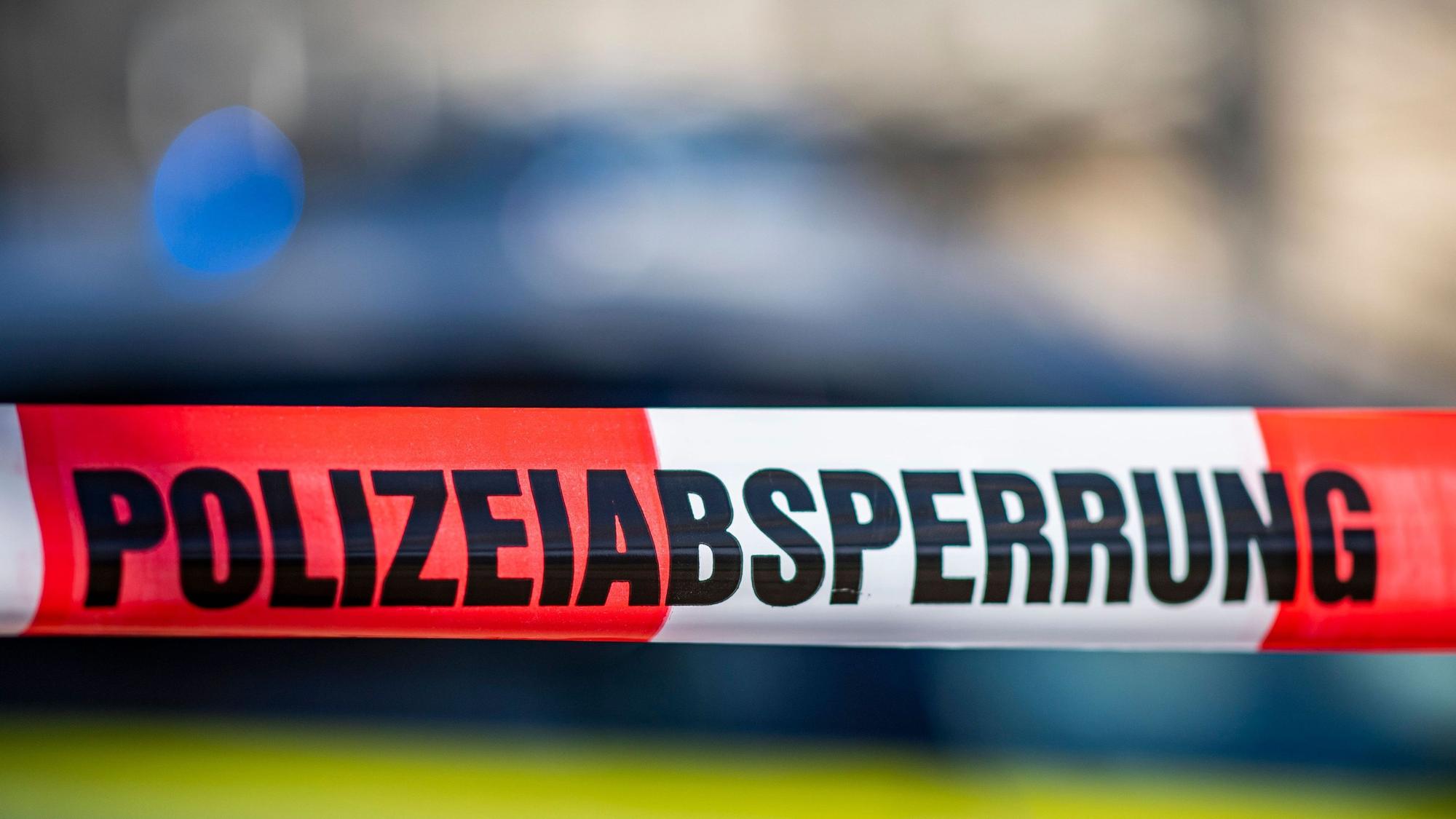 Ein Flatterband in rot-weiß mit der Aufschrift „Polizeiabsperrung“.
