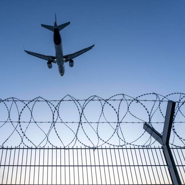 Symbolbild Sicherheit auf dem Flughafen, äußerer Zaun am Airport Düsseldorf International, Stahldrahtzaun, mit S-Draht Rollen, NATO-Draht, auf der Zaunkrone, Flugzeug im Landeanflug, Sonnenuntergang, NRW, Deutschland, Sicherheit Flughafen *** Symbolic image security at the airport, outer fence at Düsseldorf International Airport, steel wire fence, with S wire rolls, NATO wire, on the fence top, airplane approaching, sunset, NRW, Germany, airport security