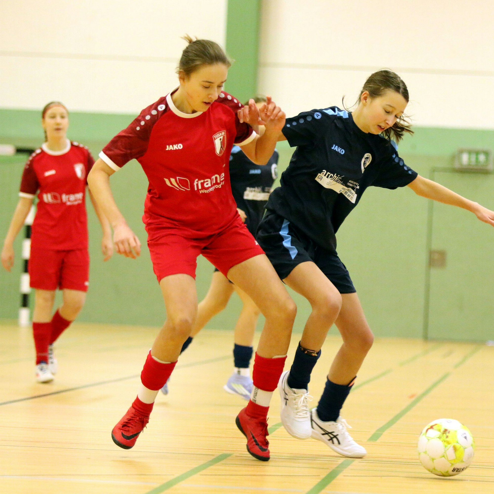 Eine Jugendspielerin des VfL Kommern im Zweikampf mit einer Gegenspielerin. Beide Mädchen arbeiten mit den Armen.